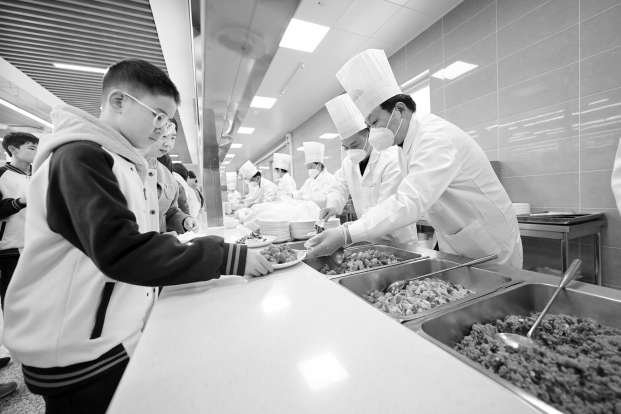 学生在食堂窗口打饭。本报记者 潘之望 摄