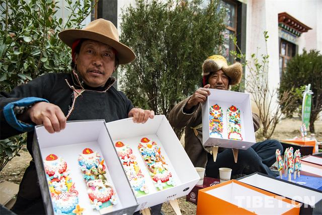 图为在拉萨市八廓商城东侧，罗布大叔（左）与其他农牧民一起售卖酥油花 摄影：赵振宇