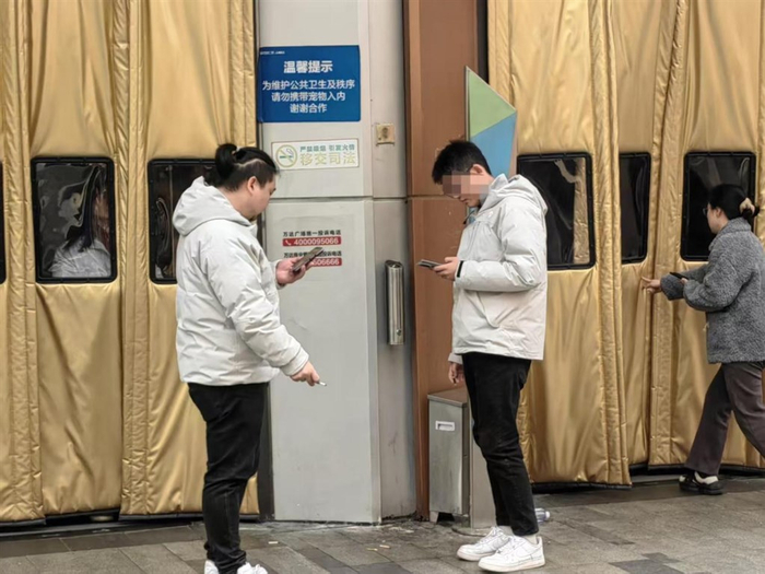 图说：2月23日，松江万达商场的顾客出入口处设有一个烟蒂垃圾桶。 陈丽娜 摄