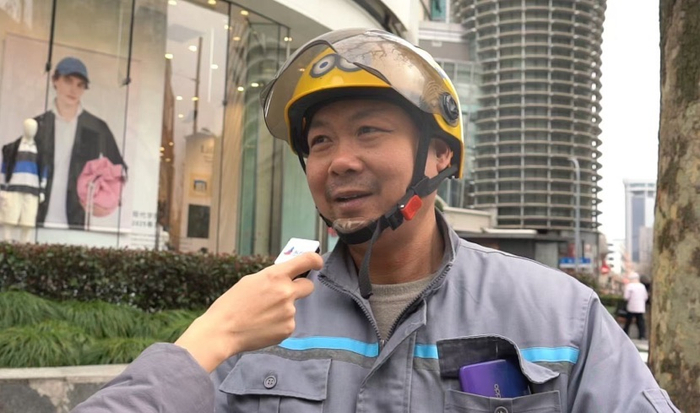 图说：2月20日，一名在南京西路张园附近工作的环卫工人纵相新闻接受采访。