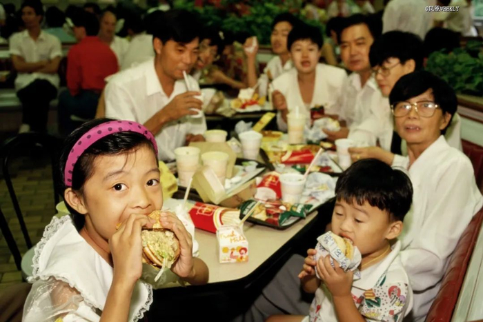 〓 1993年7月，广东深圳，家长们带着孩子在麦当劳吃汉堡。