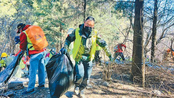 　　志愿者在山间林下清理垃圾。 本报记者 褚英硕 摄
