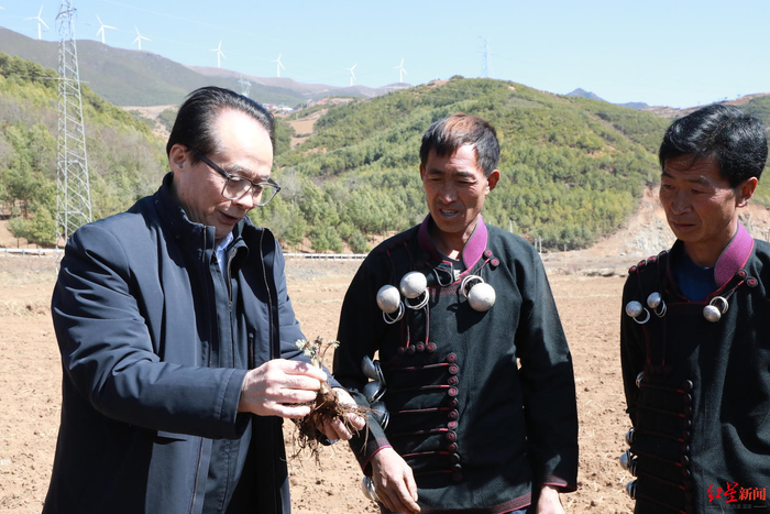 ▲耿福能在药材基地和农户交流