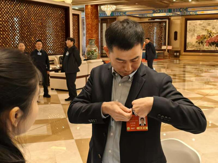 3月3日，北京会议中心驻地，出席十四届全国人大三次会议的北京团代表佩戴代表证。中青报·中青网记者 尹希宁/摄