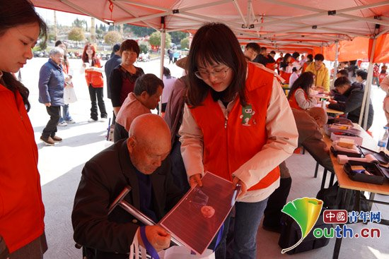 南京师范大学研支团志愿者将在公益活动中制作的照片送到老人手中。南京师大研支团供图