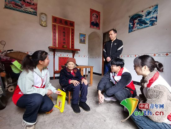 广西壮族自治区恭城瑶族自治县西部计划志愿者服务队成员在龙虎乡龙湖村与老人聊天。团恭城瑶族自治县委供图