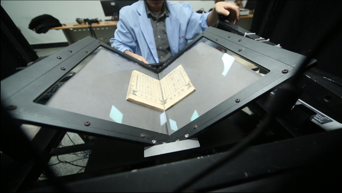 工作人员在扫描象棋古谱（成都时代出版社提供）