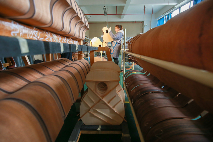 正安吉他产业园一家吉他制造厂工作人员查看产品质量。王纯亮 摄（贵州图片库发）