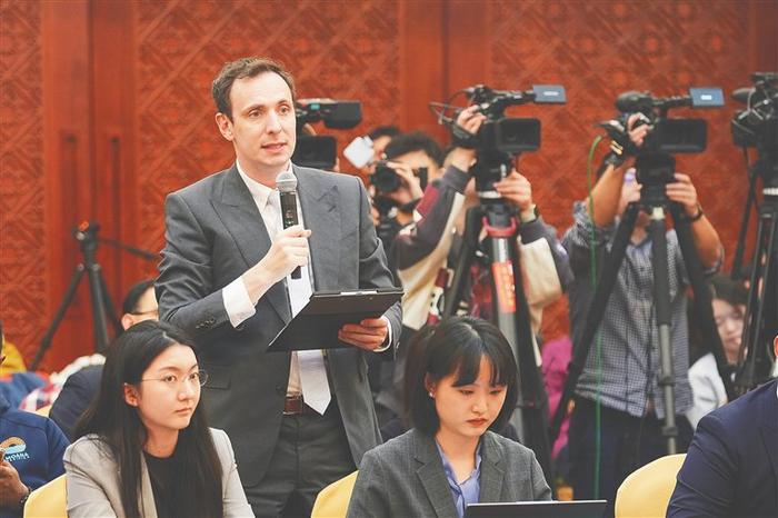 海南代表团开放团组活动现场，各家媒体进行提问、采访、拍摄。