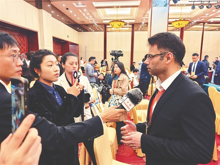 海南代表团开放团组活动现场，各家媒体进行提问、采访、拍摄。