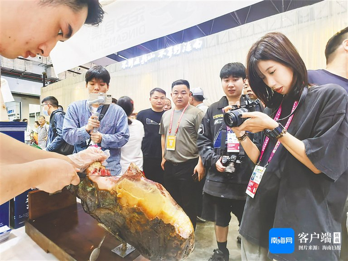 在第二十七届冬交会定安馆，张永新用定安黑猪后腿研制的西班牙风味火腿吸引了不少关注。资料图