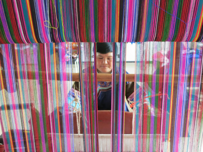 余晶凤在龙布瑞刺绣工艺品专业合作社里织锦（资料图）。