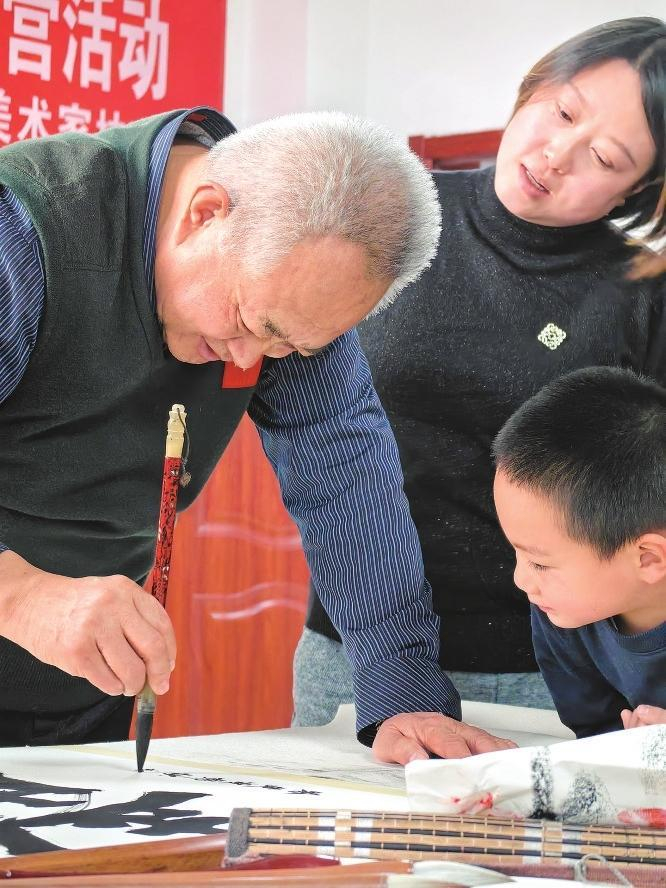 小朋友向书法爱好者虚心求教。兰州新区报记者姜波 摄