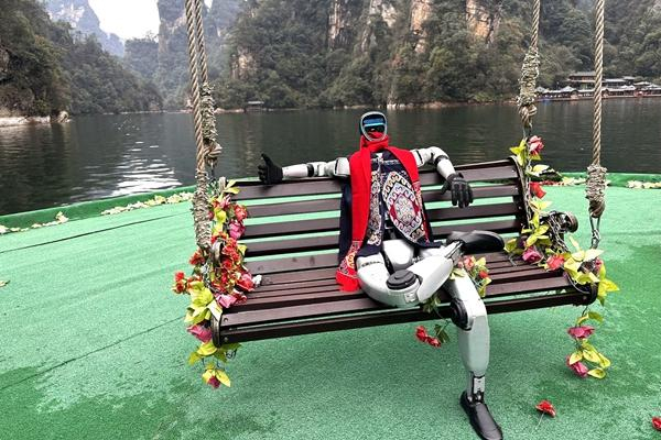 3月10日，湖南张家界，机器人“笨笨”戴着围巾坐在张家界风景区的椅子上。受访者供图