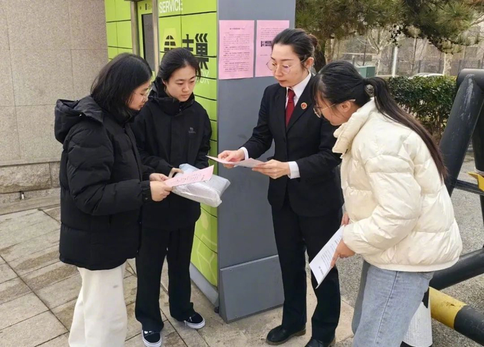 2024年12月29日，山东省青岛市崂山区检察院办案检察官在快递取件点张贴反诈提示并现场宣讲。