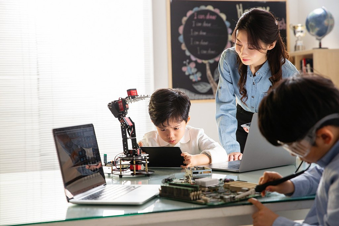 小学生正在学习利用AI操纵机械。（图源：视觉中国）