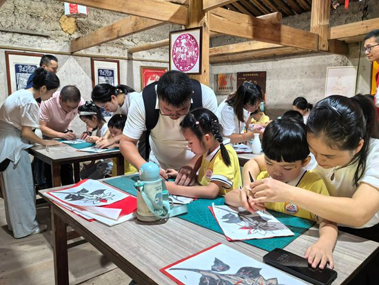 在杨梅乡云溪村家风家训馆，小学生体验刻纸非遗。李宏图 供图