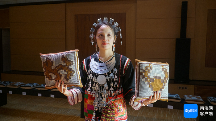谭朝艳在巴黎时装周现场展示黎锦抱枕。记者 余育桑 摄
