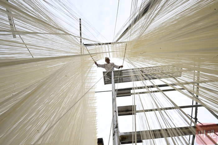 挂面师傅站在5米高的木架上挂面。肖开丰 摄