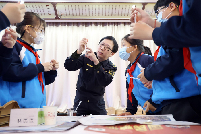 工作人员走进学校向学生讲解快速检测知识。