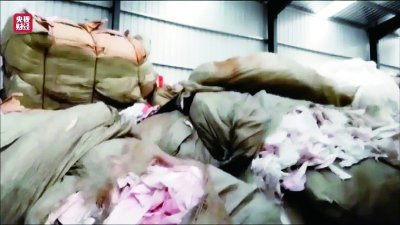     涉事企业仓库中堆满成吨采购回来的纸尿裤、卫生巾的生产垃圾。 视频截图