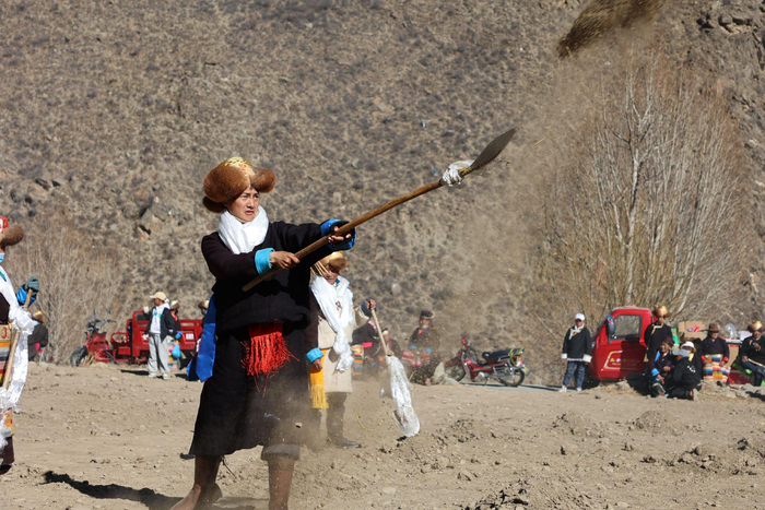 图为村里的年轻小伙第一个播撒农家肥