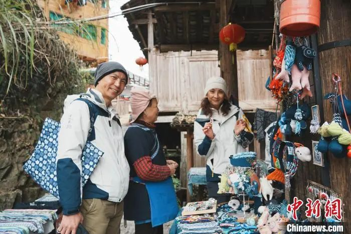  游客在贵州大利侗寨挑选旅游商品。周燕玲 摄
