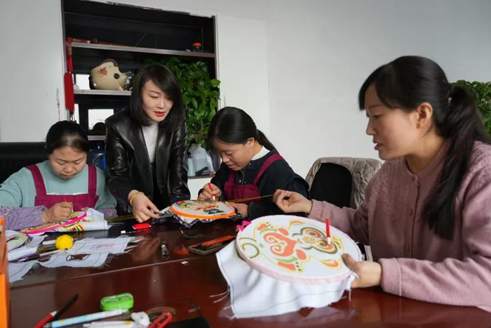 高广娟（左二）指导妇女做针织产品。固原市原州区融媒体中心供图