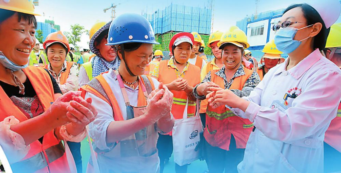 医护人员向工人普及卫生知识。记者 陈飞 摄