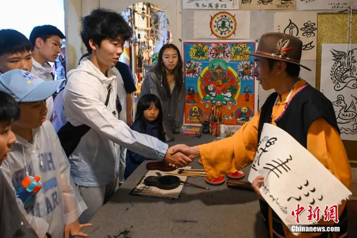  图为华裔青少年体验东巴文化。中新社记者 李嘉娴 摄