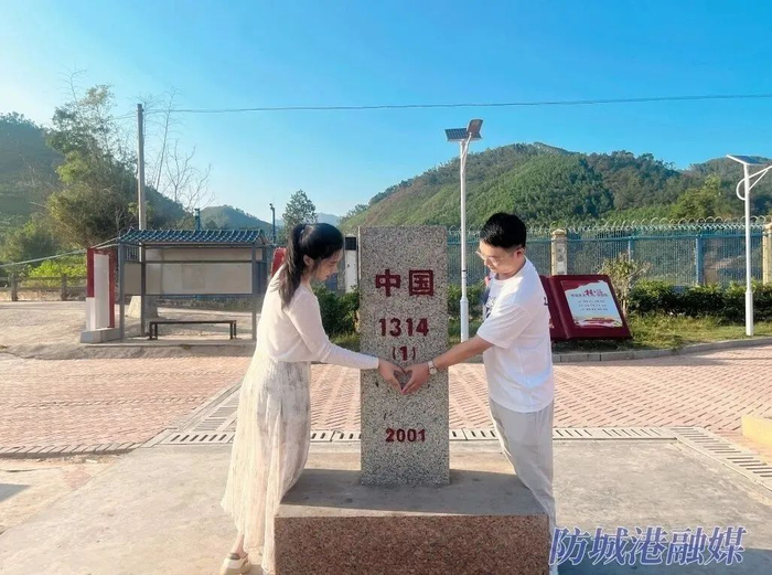 情侣在峒中镇同心文化广场（1314号界碑）打卡。（资料图）