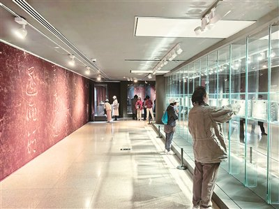 图为观众在仔细观赏肃府本《淳化阁帖》刻石。