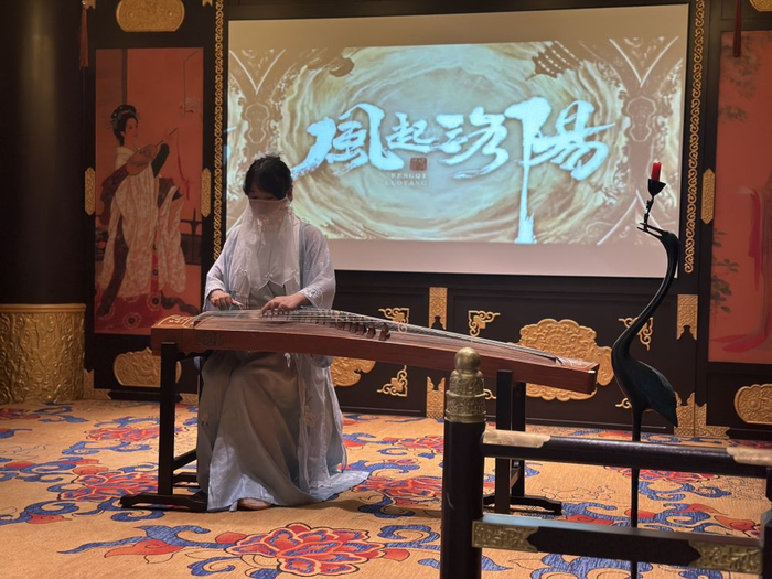 　　  《风起洛阳》VR全感剧场内，身着古装的演艺人员现场弹奏古筝。新华社发（姜艺莎摄）