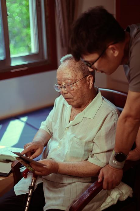 张琤淙与老人交谈老照片故事。受访者供图