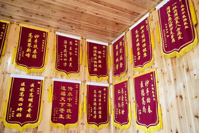 康复者们赠送的锦旗挂满了墙。