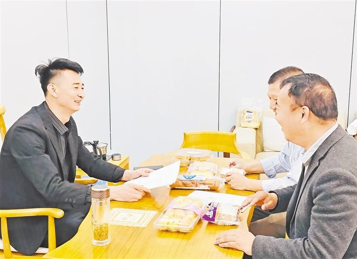 马国军（左）在和客户谈业务。