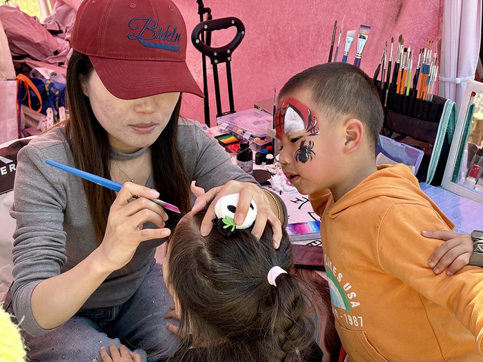 钱多多（化名）为小朋友进行面部彩绘。澎湃新闻记者 陈悦 图