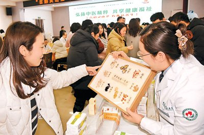 在山东省青岛市西海岸新区灵山卫街道，居民在中医健康市集上了解中药材知识。新华社记者 李紫恒摄