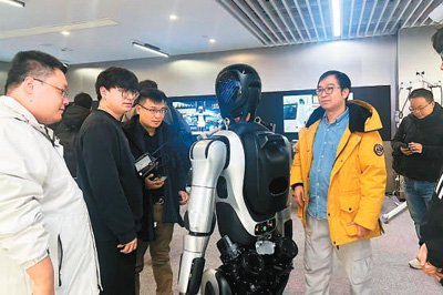图为沈赐恩（左三）与国内机器人研发团队讨论机器人性能。受访者供图