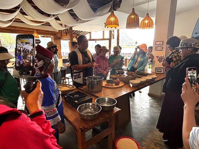 旅居游客体验花米饭制作过程（3月24日摄）。殷照领 摄