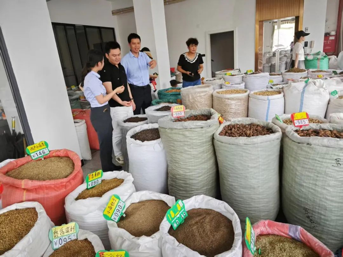 ▲农行广西玉林分行客户经理走进当地香料市场，了解商户经营情况。