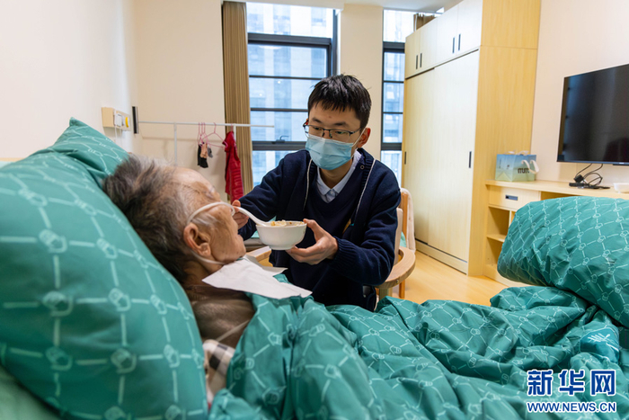   张锐在喂老人吃饭，掌握每个老人的口味十分重要（3月18日摄）。新华网 李浩 摄