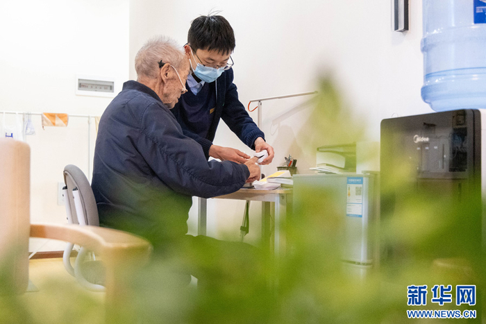 张锐为老人进行日常身体检查（3月18日摄）。新华网 李浩 摄