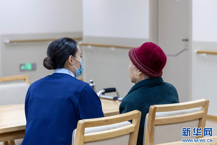 杨玉娇和老人聊天谈心（3月18日摄）。新华网 李浩 摄