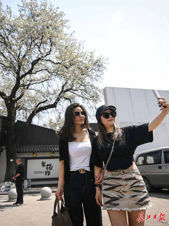 位于硚口区汉西三路华中建材市场内的一棵百年杜梨树迎来盛花期，吸引市民游客打卡拍照。 长江日报记者史伟 摄