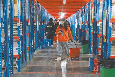 　　书友在涿州仓库书架中选购图书。熊华明摄