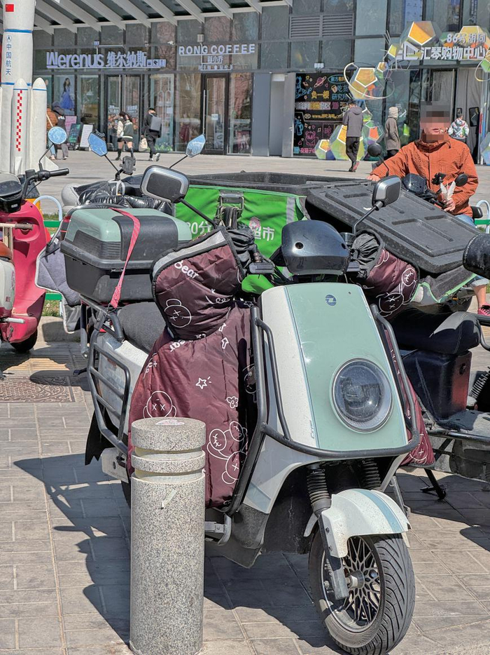 3月29日下午，汇琴购物中心，有人在商场门前停车区抽烟。 新京报记者 王景曦 摄