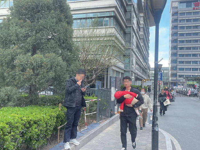 3月28日下午，首都医科大学附属北京儿童医院东门南侧入口附近，有市民在此吸烟。患儿和家长在此往来。 新京报记者 吴婷婷 摄