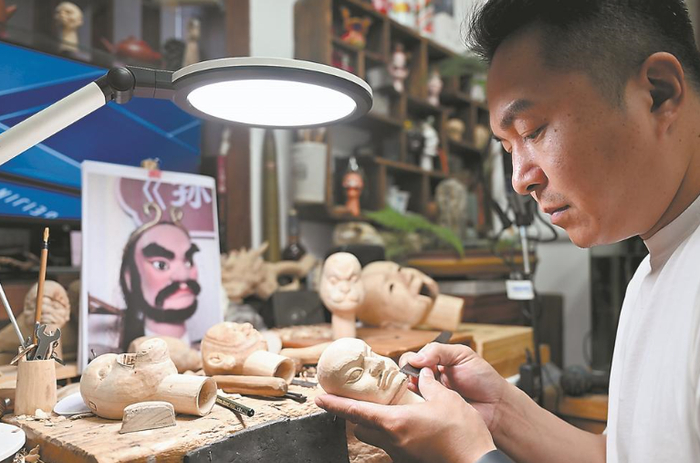 “漳州木偶头雕刻”市级传承人林城盟在为《三打白骨精》重新制作木偶。 施辰静 摄