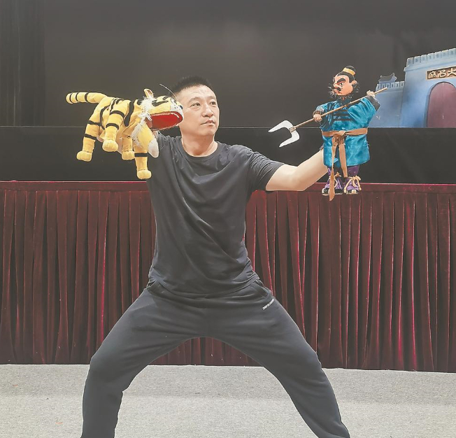 漳州市布袋木偶传承保护中心副主任梁志煌在表演经典布袋木偶戏《两个猎人》，展示“两手对打”的绝活。 赵文娟 摄